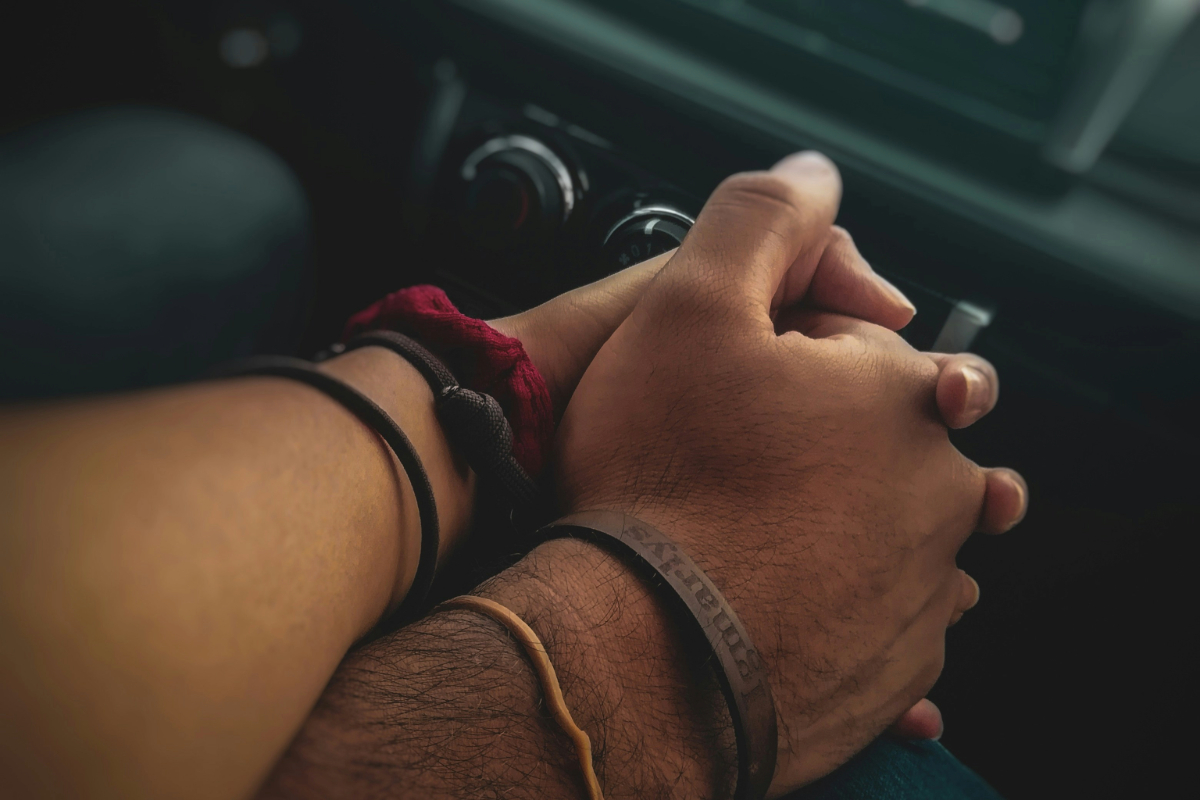 Couple holding hands in a car, representing unmarried partners going to rehab together